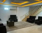 سالن نشیمن با نورپرداز یلایت و پله های چوبی به مقصد طبقه دوم ویلا 56548545445654