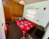 اتاق خواب با تخت 2 نفره با ملحفه قرمز و کمد دیواری چوبی ویلا در نور 1456484