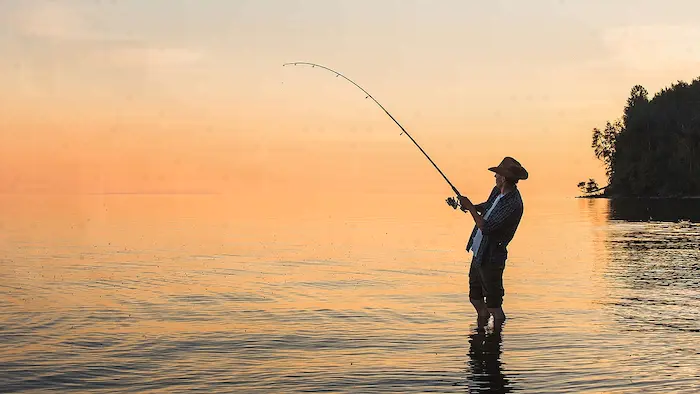 ماهیگیری مرد در داخل دریای رویان هنگام غروب آفتاب 46484485