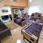 اتاق پذیرایی به همراه مبلمان کلاسیک و سالن بازی با میز فوتبال دستی ویلا در ایزدشهر 4897589478